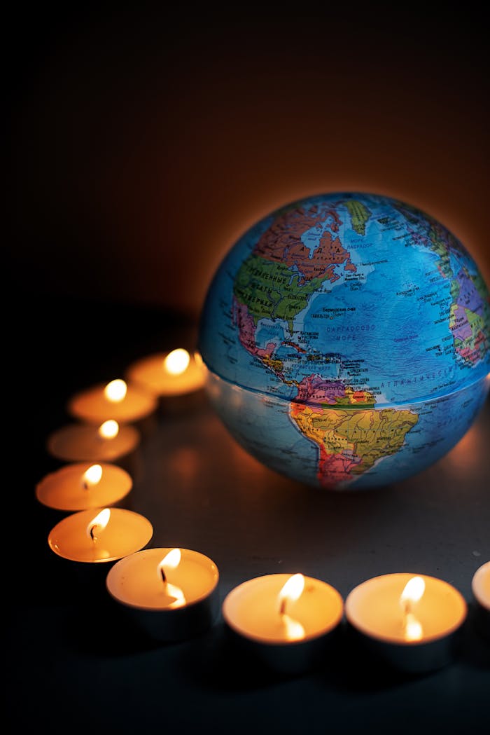 Home A globe encircled by lit candles, symbolizing global unity and peace.